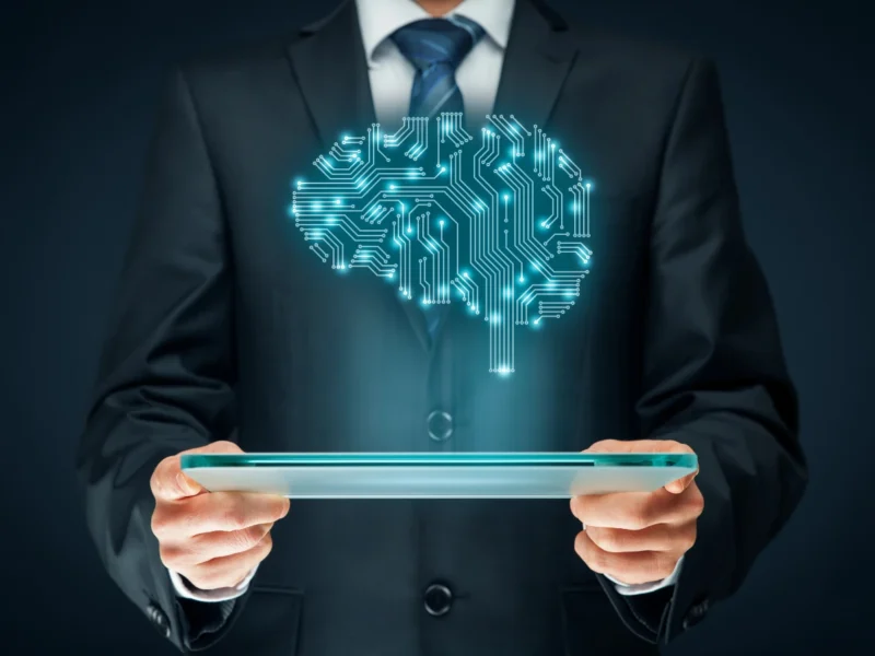an image of a person holding a tablet with a hologram of a human brain